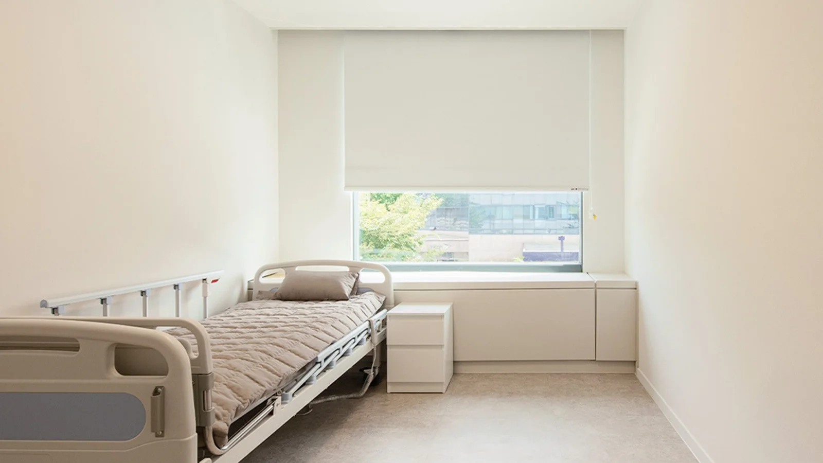 Hospital room interior for 345 Plastic Surgery where natural. Bed, window, and minimal decor.