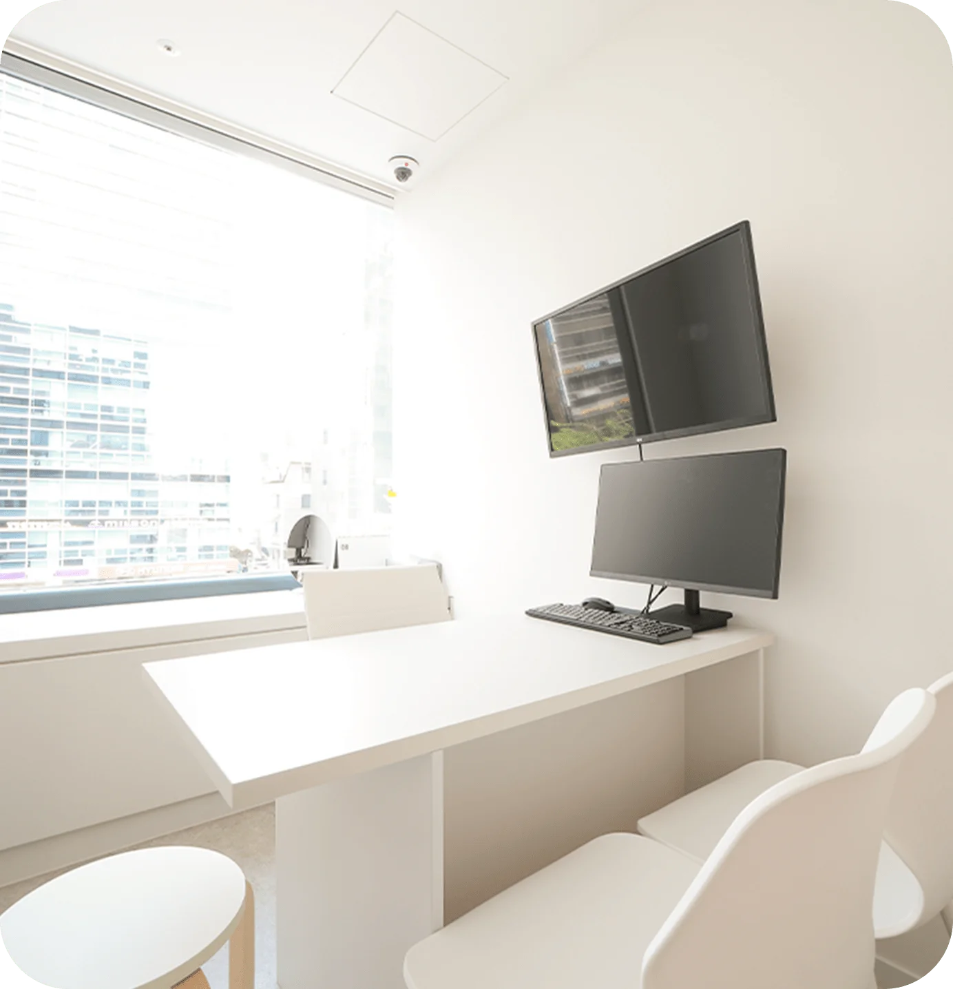 345 Plastic Surgery office interior where natural. Monitors, desk, and chairs in a bright, modern clinic.