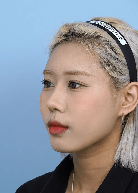 Asian woman with headband for 345 plastic surgery where natural results are desired.